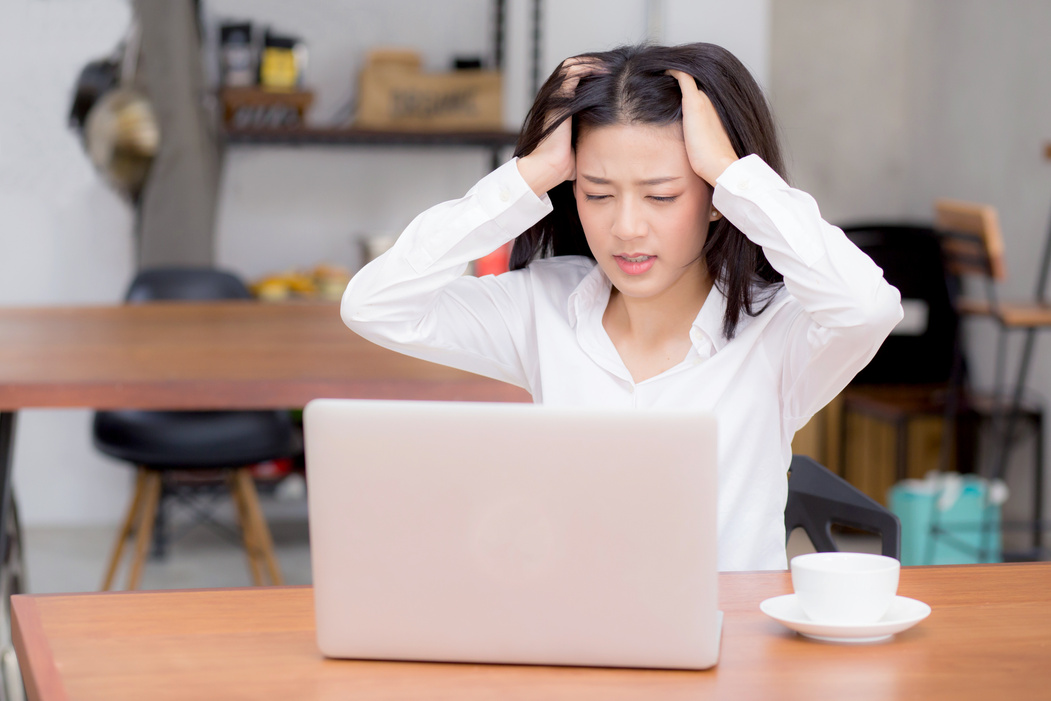 Woman Worrying While Working with Laptop